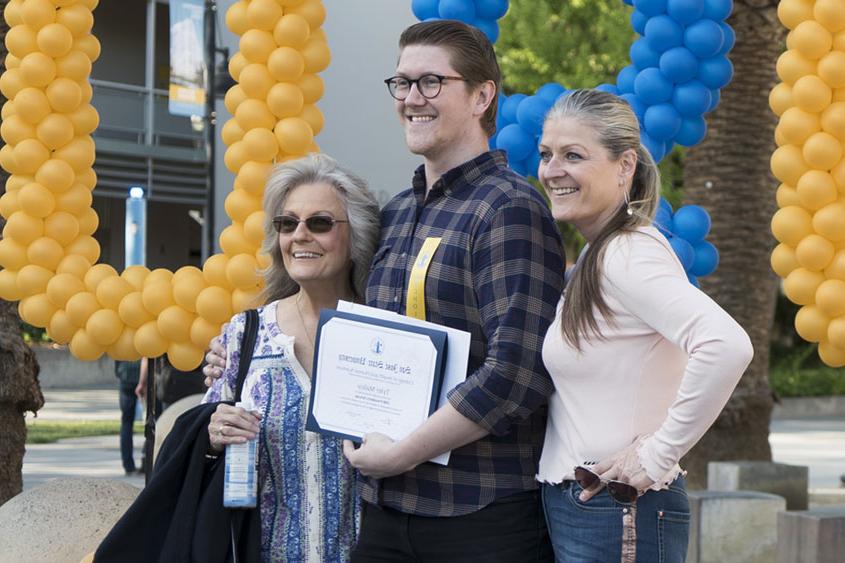 Student holding his award and posing with family.